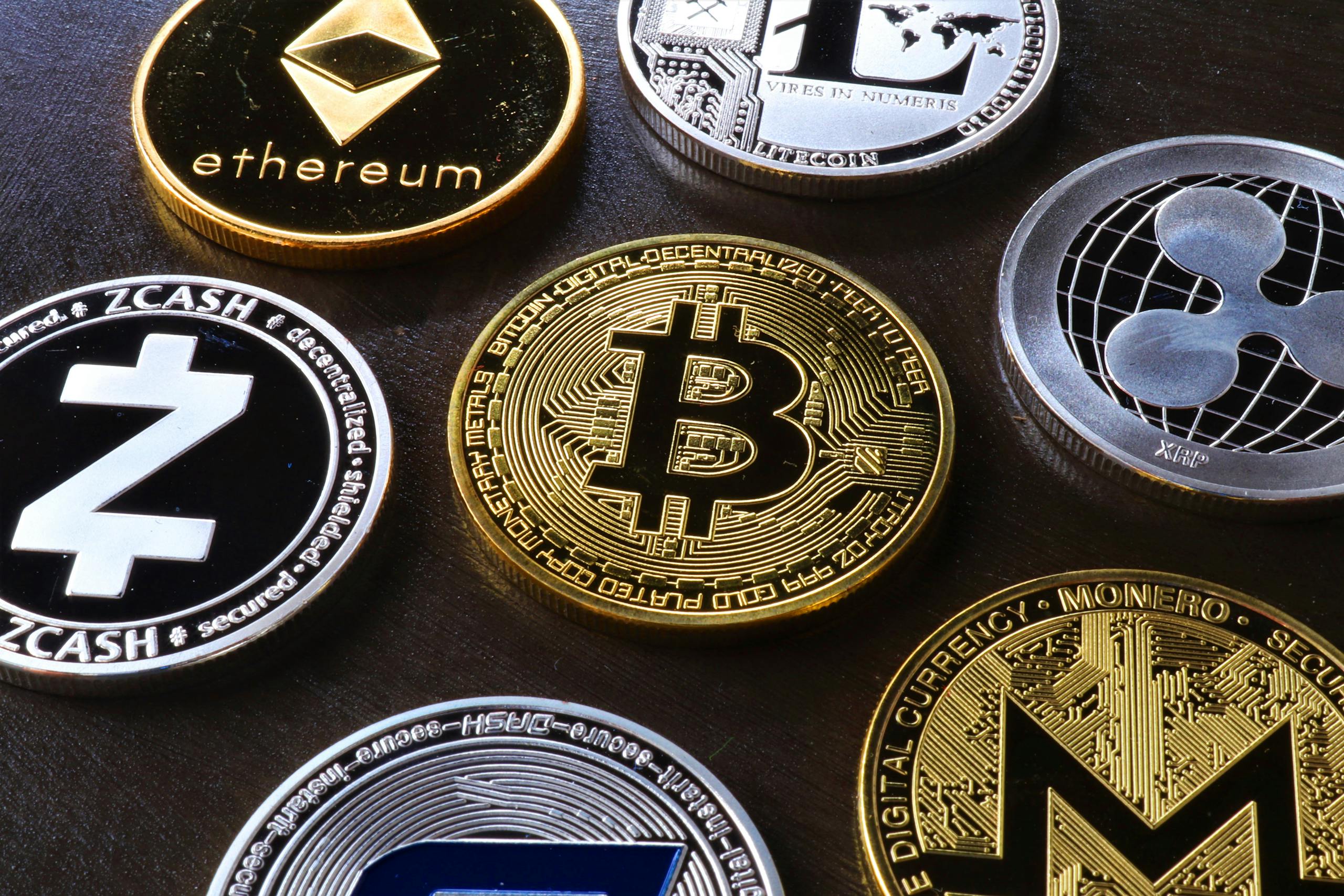 Detailed view of assorted cryptocurrency coins including Bitcoin, Ethereum, and Ripple.